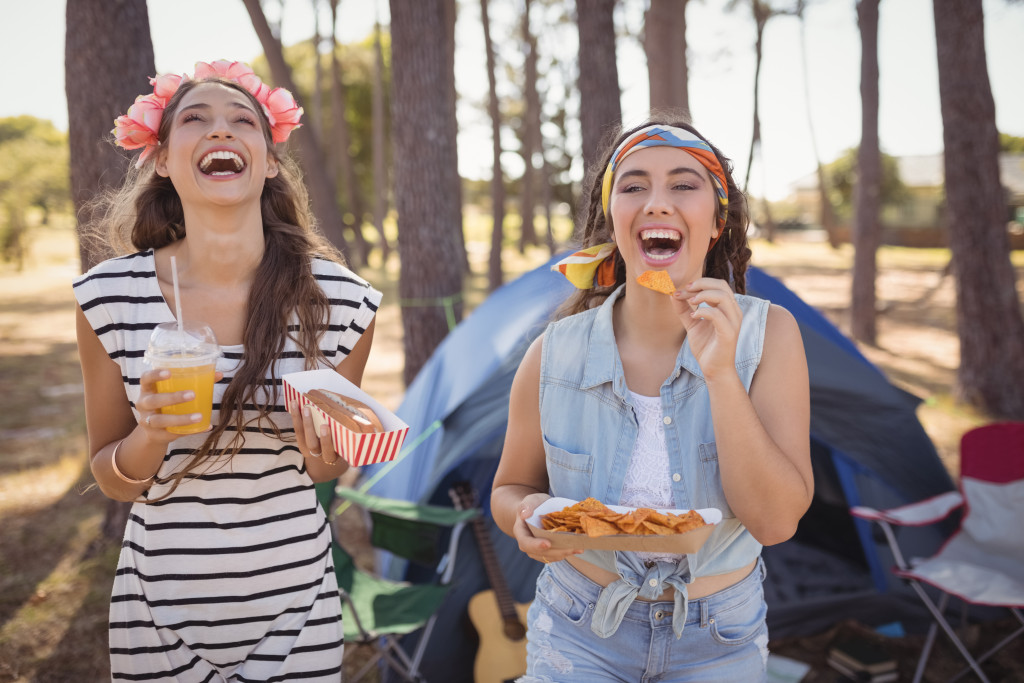 Happy girls eating on an outdoor camping site